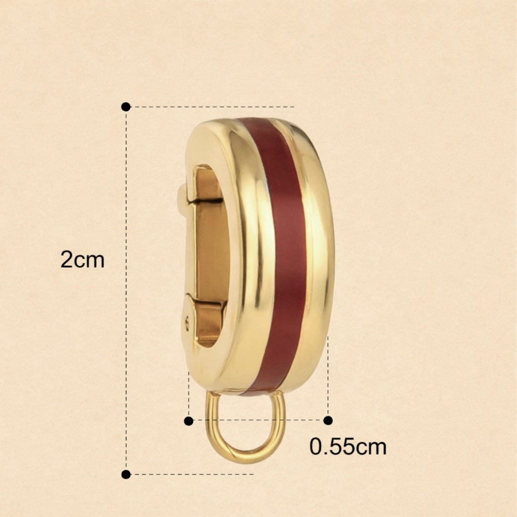 Gold and red enamel bikini clip on with measurements on a white background