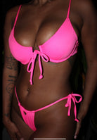 A woman wearing a neon pink bikini.