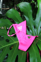 A neon pink bottom on a green leaf.