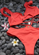A red bikini on top of gray stones.