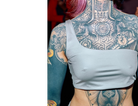An asymmetrical silber bikini top on a tattooed woman.