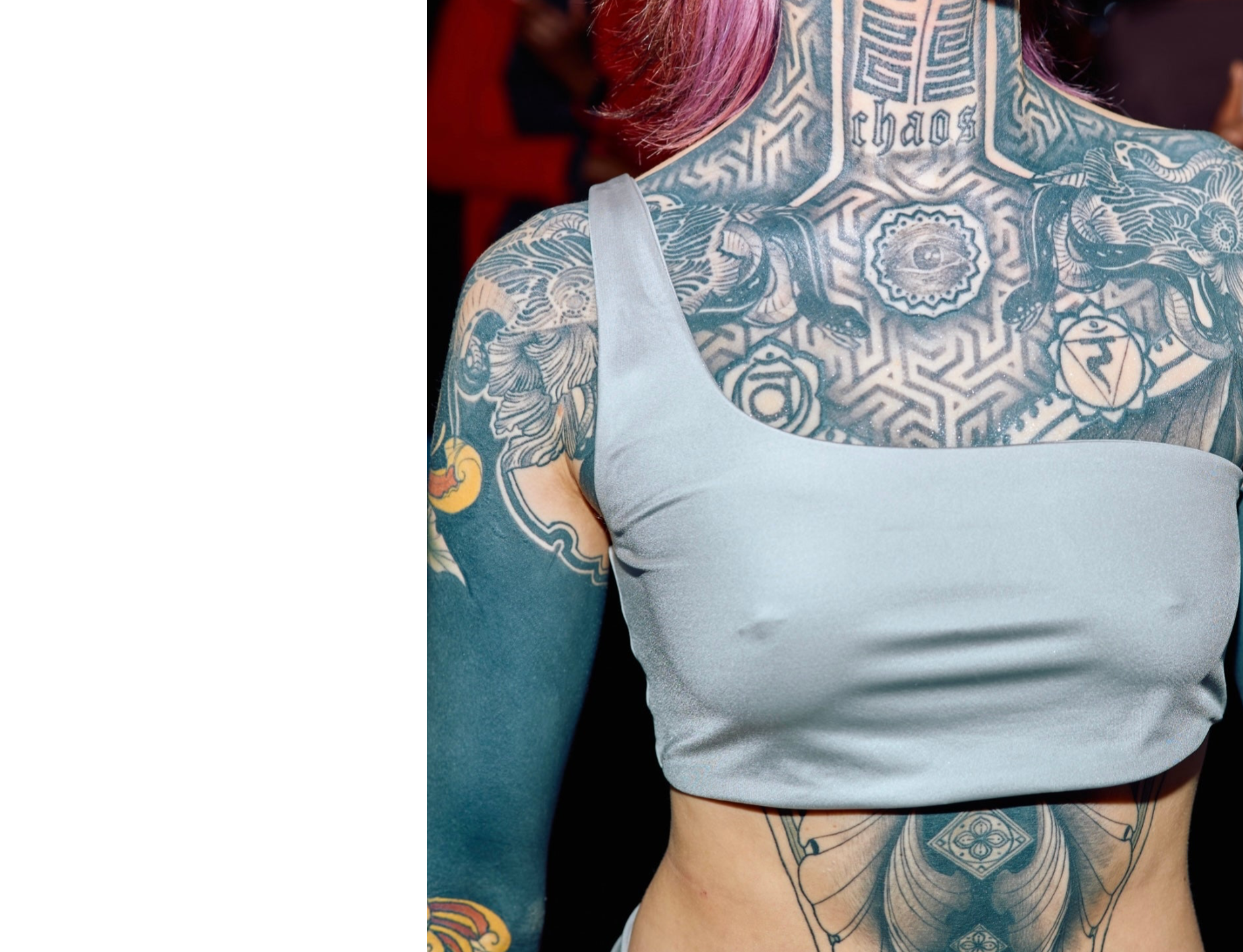 An asymmetrical silber bikini top on a tattooed woman.