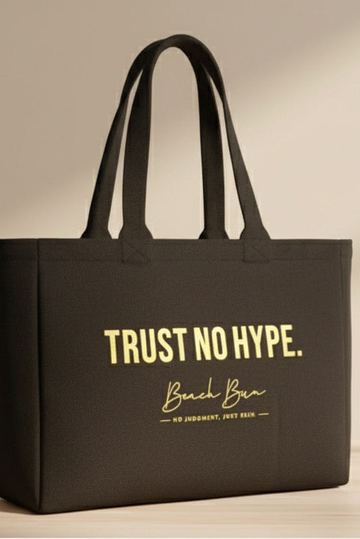 Black tote bag with 'Trust No Hype' text on a light wooden surface