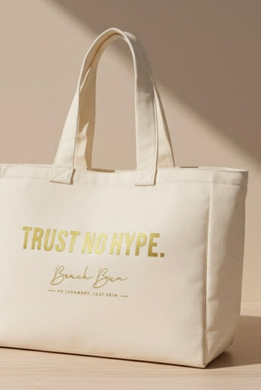 Beige tote bag with 'Trust No Hype' text on a light wooden surface