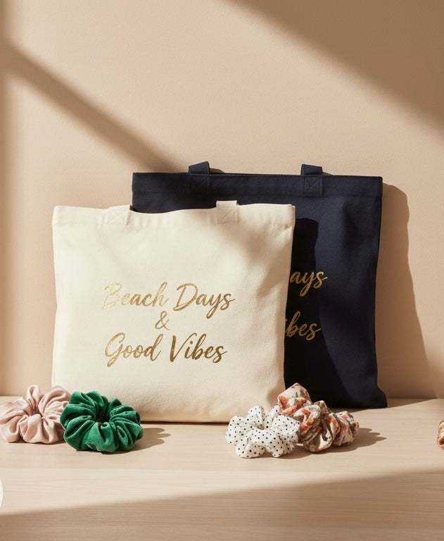 A product shot of a collection of accessories, including canvas tote bags and a variety of colorful scrunchies, for sale on a wooden surface.