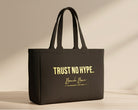 Black tote bag with 'Trust No Hype' text on a light wooden surface