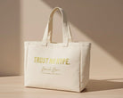 Beige tote bag with 'Trust No Hype' text on a light wooden surface